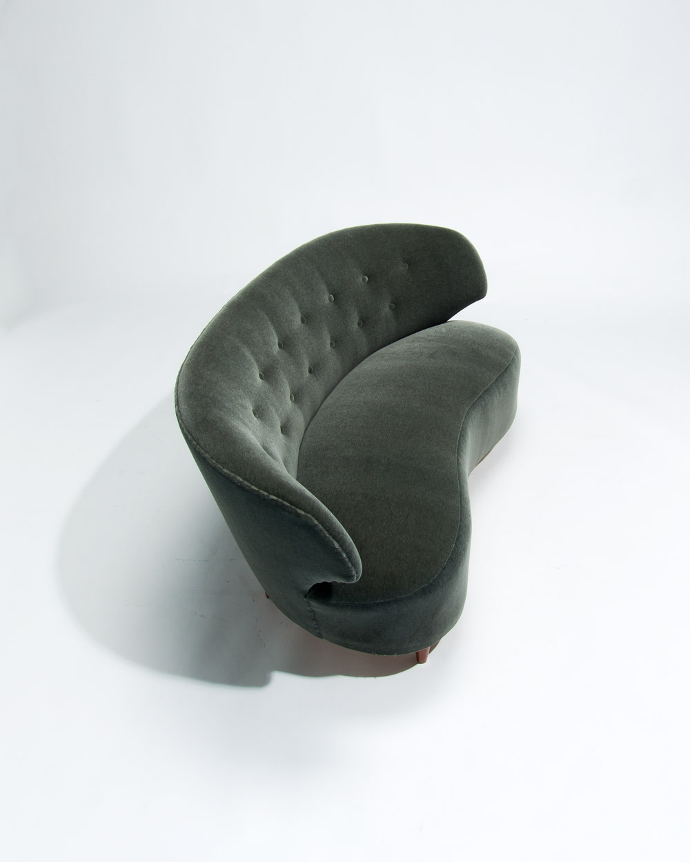 Top view of Boman sofa highlighting curve and sheen of green Dedar mohair velvet