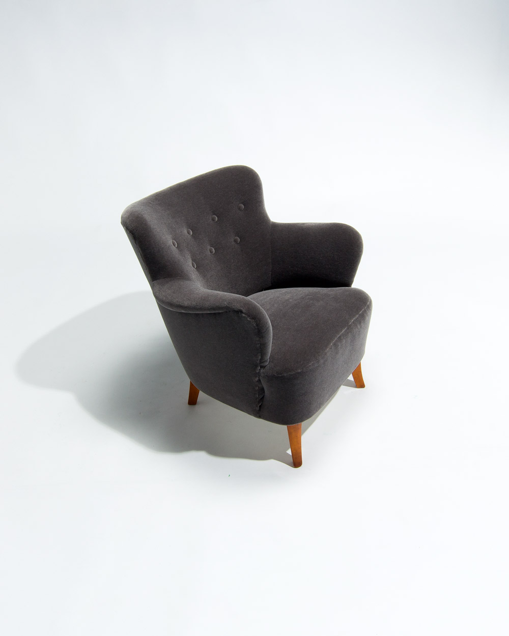 Detail of Finnish armchair in grey mohair velvet by Rose Uniacke showing curved back and seat