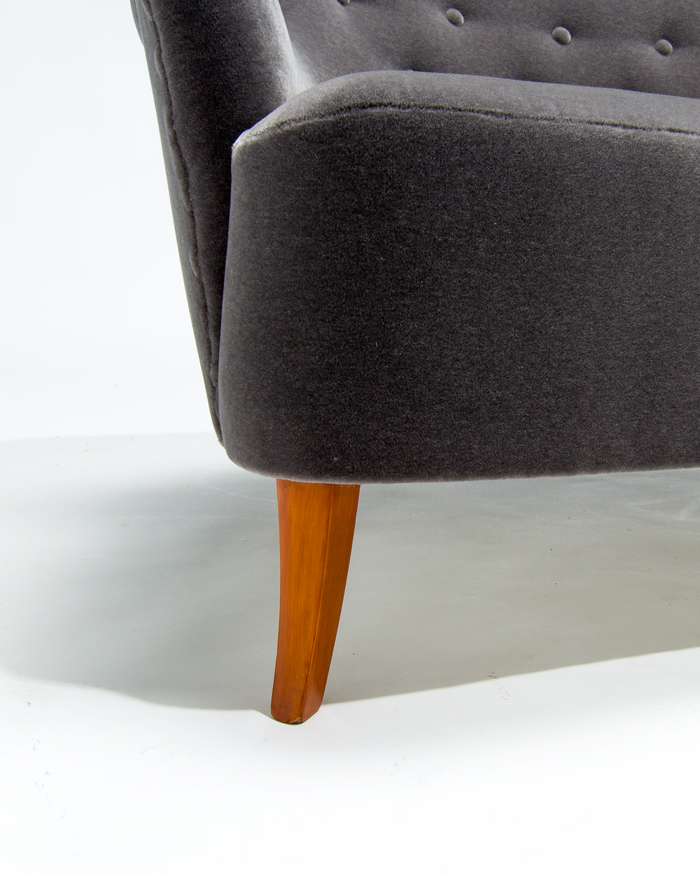 Close up of birch wood leg on Finnish mid century sofa, restored and polished, grey mohair upholstery