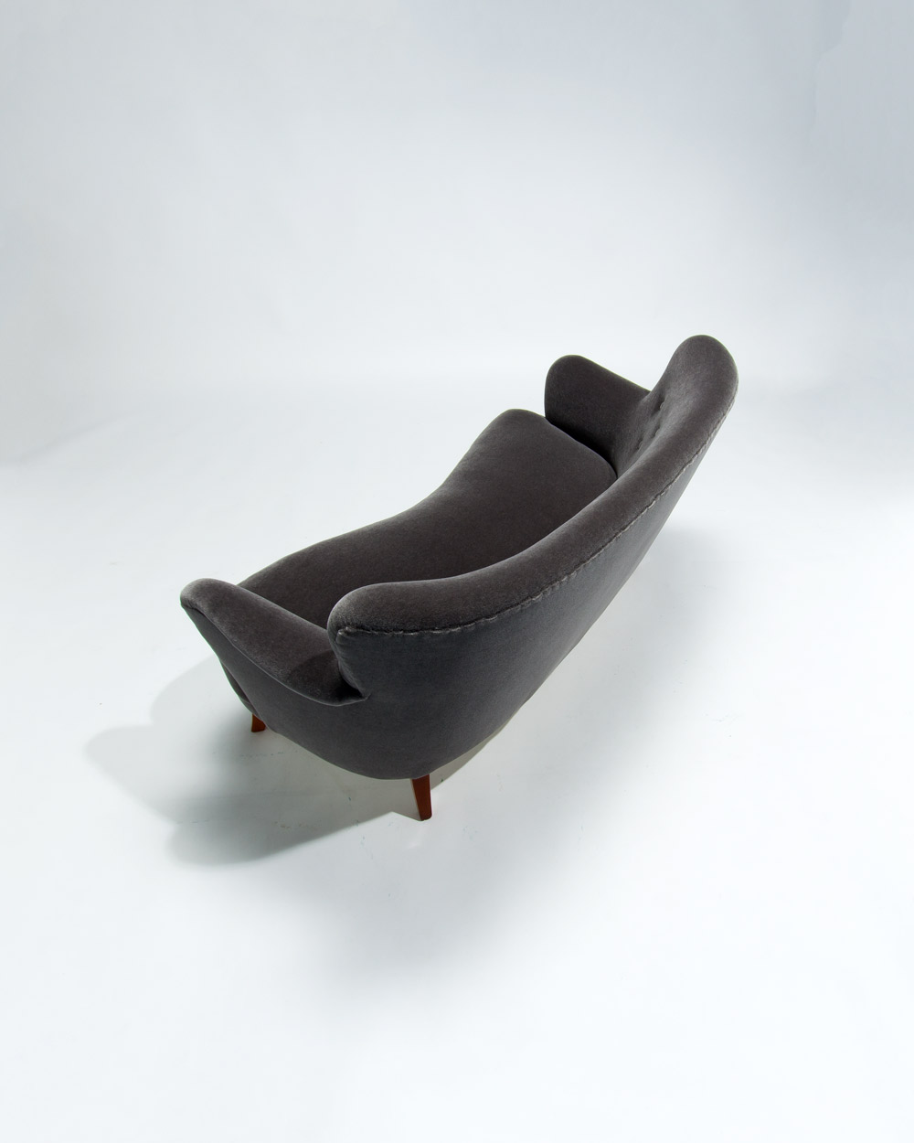High angle rear view of Finnish mid century sofa in grey mohair velvet showing flowing lines