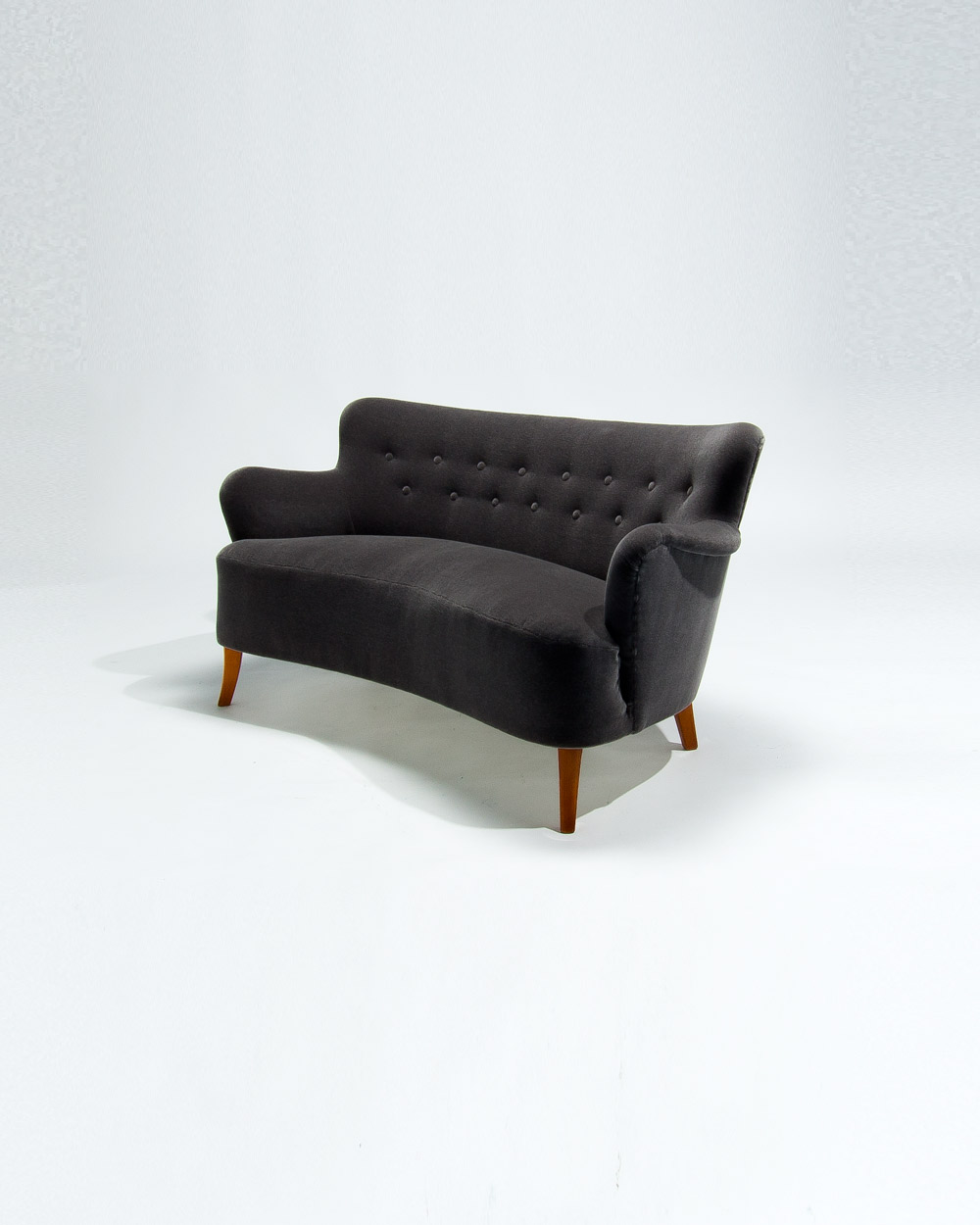Side profile of Finnish mid century sofa showing sculptural arms and grey mohair velvet upholstery