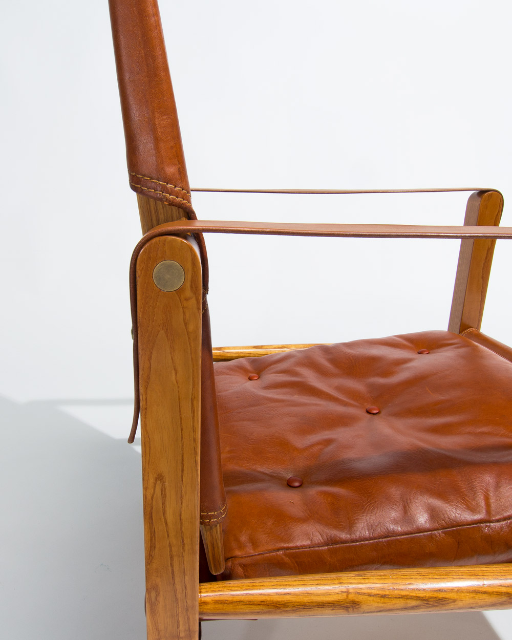 Close up of oak frame and leather upholstery on Kaare Klint Safari chair
